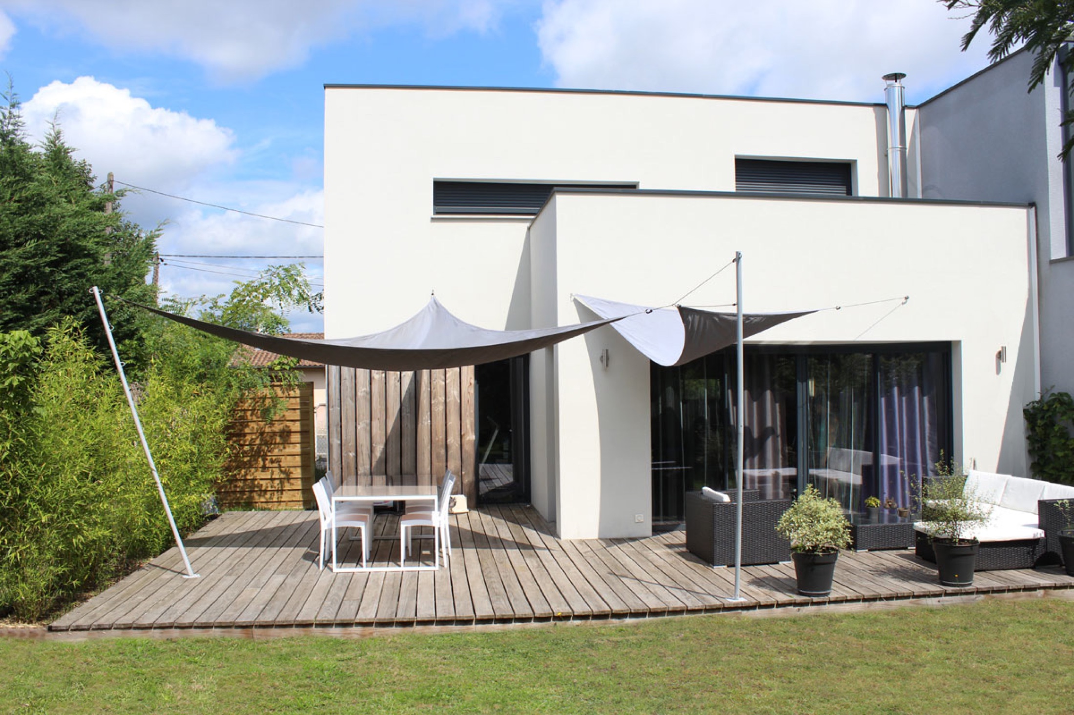 Maison contemporaine blanche ouverte sur une terrasse